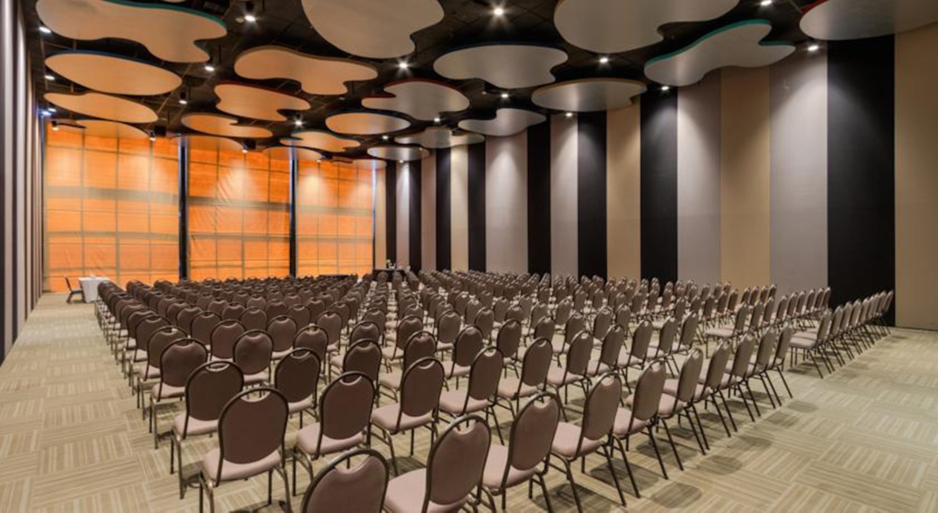 Royal Tulip Brasilia Alvorada Hotel ภายนอก รูปภาพ The photo shows a large conference or event space filled with numerous empty chairs arranged in rows. The chairs have a simple design, with cushioned seats and backs. The walls of the room are decorated with a combination of dark and light tones, and